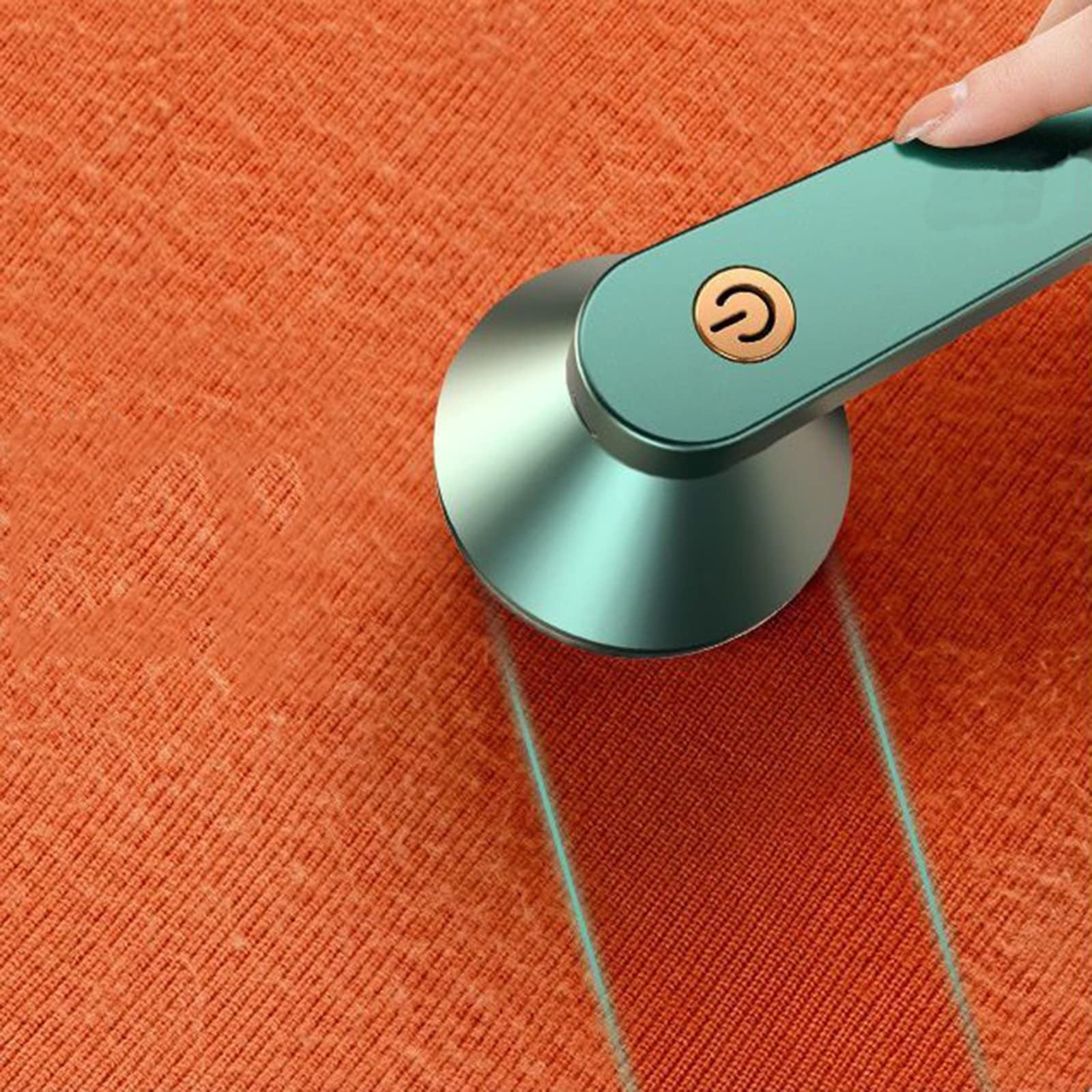 Portable fabric shaver, USB rechargeable lint remover on orange fabric.